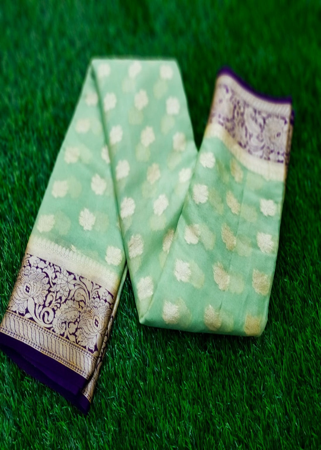 Pure handloom chiffon saree in light green color. Saree has a delicate chiffon zari border with Gorgeous unique Motifs near pallu. The entire saree is beautiful with buti design. It is an elegant traditional Banarasi saree. Irresistible wedding collection. This Mesmerising Saree is a Combination of Elegance and Style.